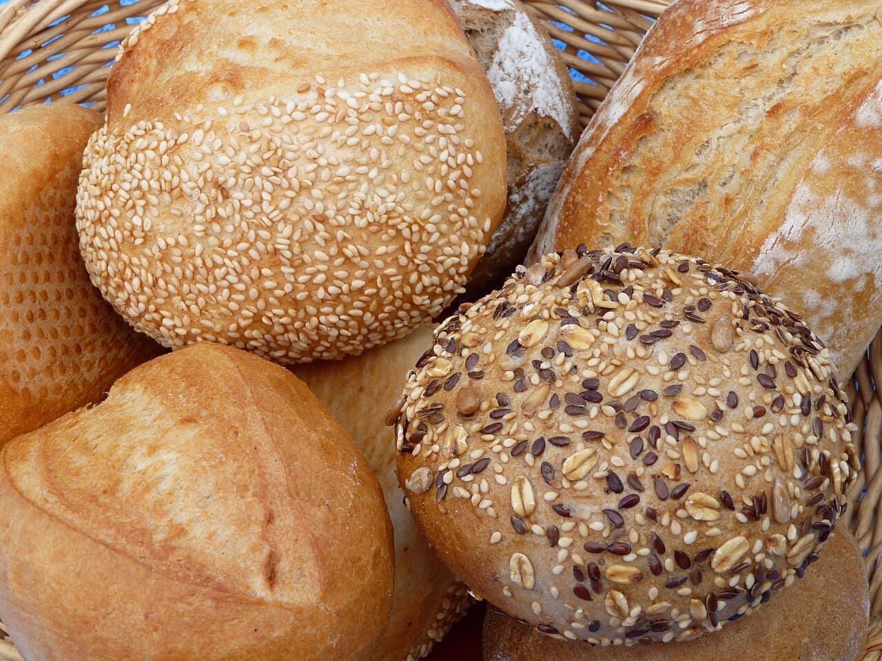 A basket of seeded and flour-dusted bread rolls